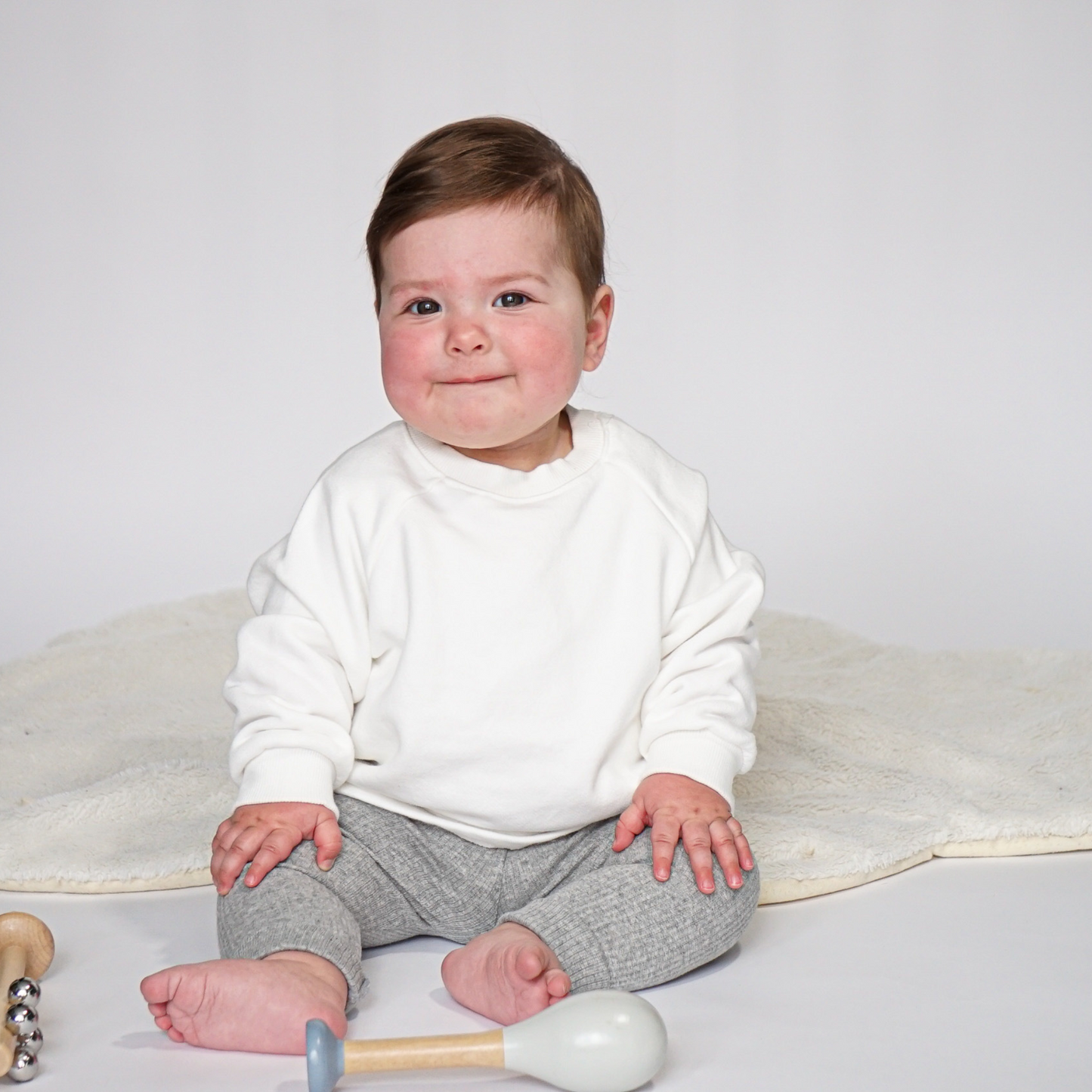 child in ivory jumper and grey ribbed leggings